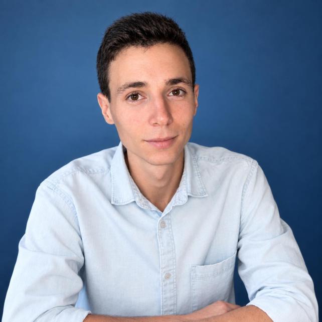 Professional headshot of a construction cost consultant wearing a suit, neutral office background, soft natural light, confident friendly expression, high quality photo